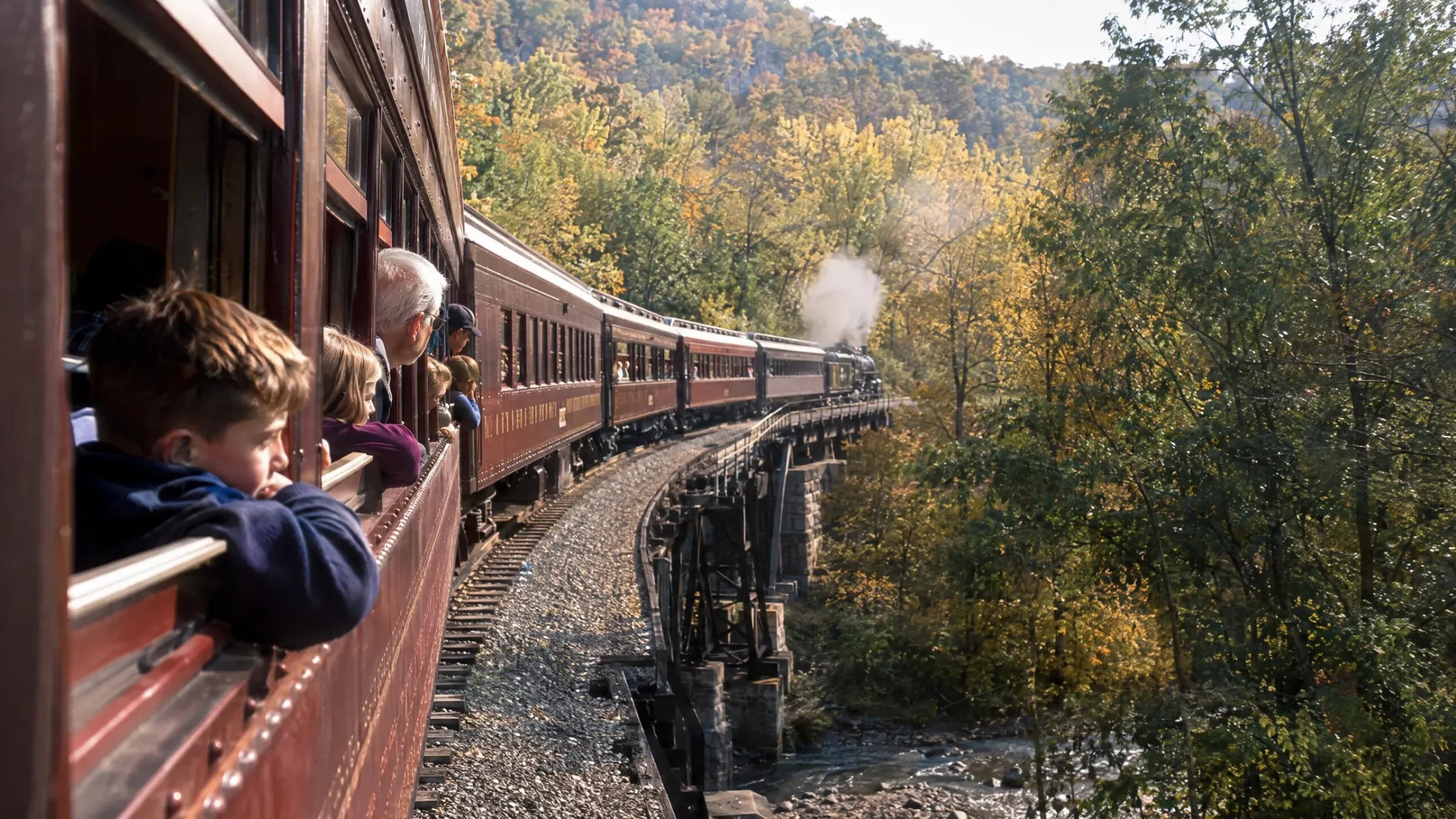 Family and older passengers watching the Western New York landscape from a vintage train